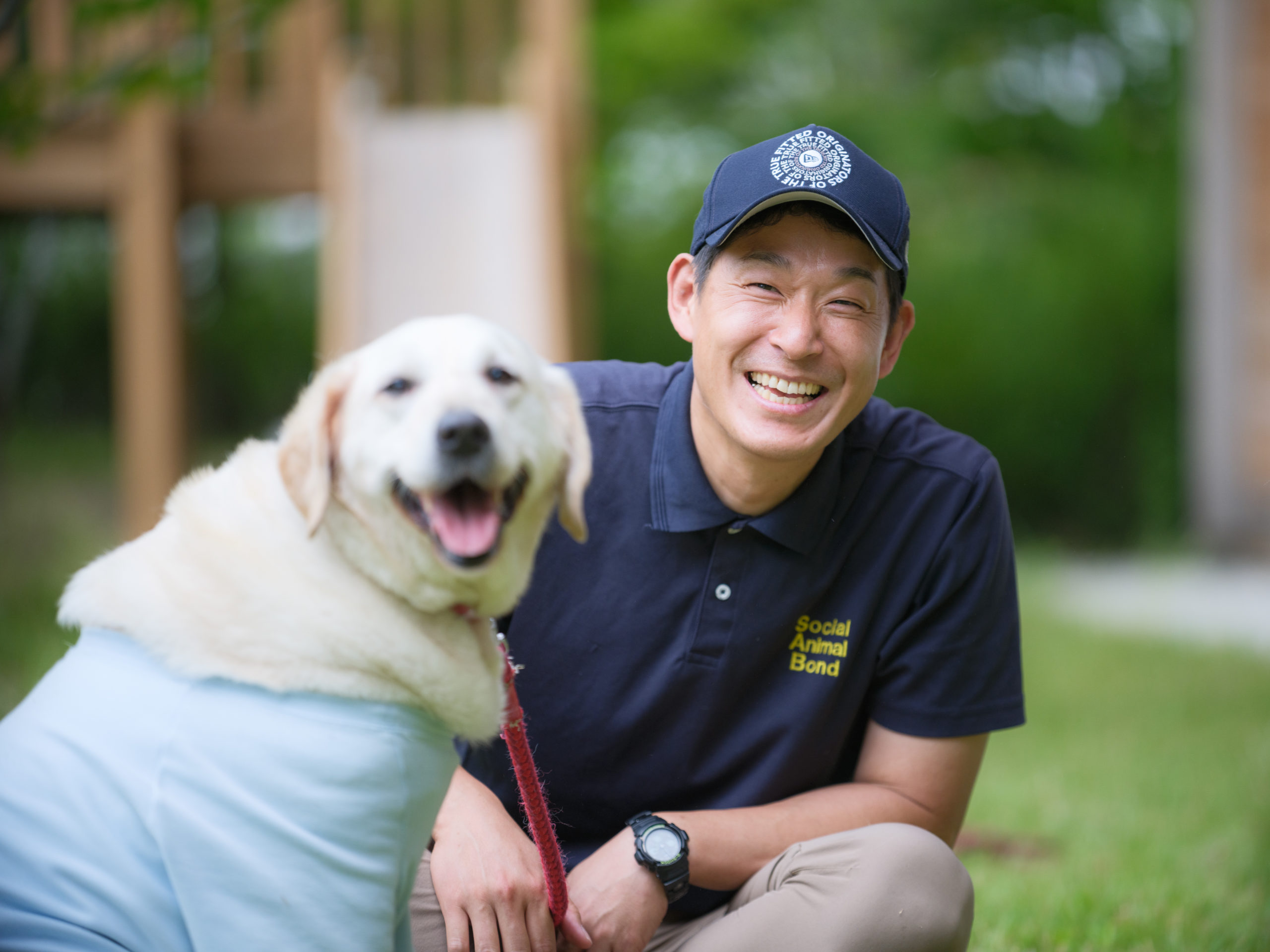 青木さんとレトリバーが微笑んでいる