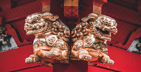 神社の建物の角に付くピカピカの一対の狛犬